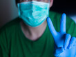 © Standby69 - The concept of protection against bacteria and viruses A man holds his finger in a mask and surgical gloves to prevent viruses and influenza.