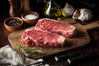 © ahirao - raw strip beef steak meat on wooden cutting board