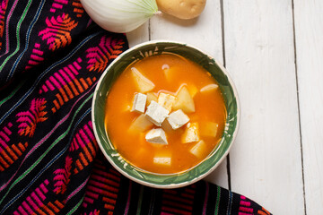 Mexican potato soup with panela cheese on white background