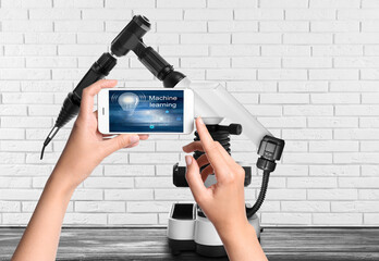 Poster - Engineer controlling electronic laboratory robot manipulator with smartphone indoors, closeup. Machine learning