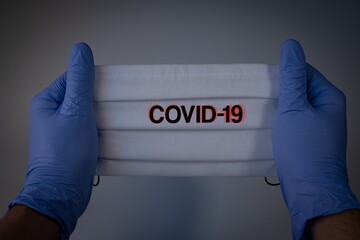 Poster - Medical gloves and mask with word Covid-19 on white background- Covid-19