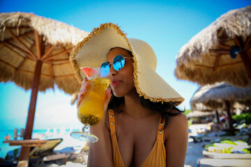 happy woman on beach drinking tropical cocktail