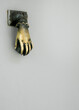 a golden hand for knocking on the door with a white background