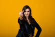 © Ivan Zelenin - Portrait of a happy young brunette girl showing gestures and smiling, surprising isolated over yellow background. Emotional picture.