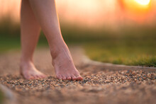 Barefoot Girl Walking On The Walkway Ground Stone With Sunset Light Shine