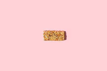 Wall Mural - One piece gluten free granola cereal snack, seed, protein energy bar with dried fruit & various nuts, pink background. Healthy vegan super food, fitness dieting snack, sporty lifestyle. Top view flyer