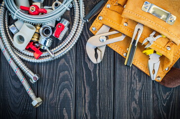 Wall Mural - Set of tools in the bag and spare parts for plumbers on dark vintage wooden boards