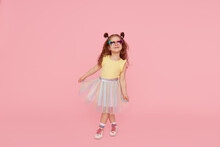 Portrait Of Surprised Cute Little Toddler Girl  In Sunglasses Over Pink Background.  Child Model Have Fun And Jump. Advertising Childrens Products