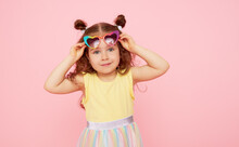 Portrait Of Surprised Cute Little Toddler Girl  In Sunglasses Over Pink Background.  Child Model Have Fun And Jump. Advertising Childrens Products