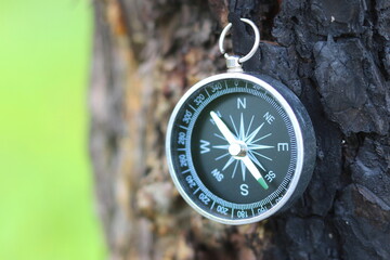 round compass on natural background as symbol of tourism, travel and outdoor activities