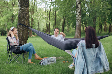 Social distancing. Small group of people enjoying conversation at picnic with social distance in summer park. Leisure activity together in new normal, gatherings following safety protocols