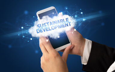 Female hand touching smartphone with SUSTAINABLE DEVELOPMENT inscription, cloud business concept