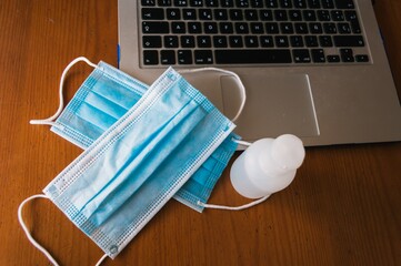 Landscape shot of two disposable masks and hand sanitizer