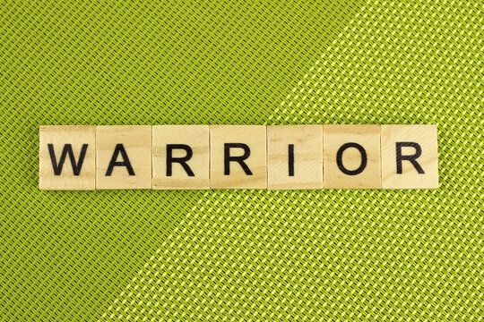 Warrior word of wooden letters on a green background