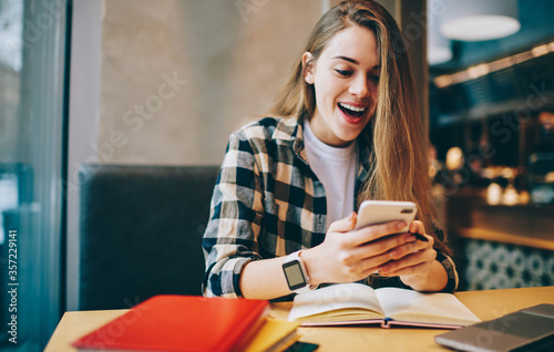 Cuadros en Lienzo Wonder amazed hipster girl received text message on mobile phone about upcoming