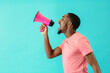 © Carlos David - Portrait of a young man shouting through megaphone with mouth open