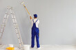 Worker painter paints a wall.Back view. Professional builder makes repairs.