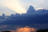 Fototapeta Na ścianę - Beautiful heavenly landscape. Dark clouds in the sky at sunset and a ray of light