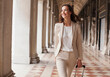 © Sam Edwards/KOTO - Confident businesswoman pulling suitcase along corridor