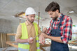 © zinkevych - Building worker in helmet applying bandage on his coworker forearm