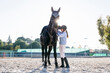 © Westend61 - Back lit young girl preparing chestnut horse on training ground against clear sky