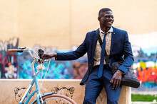 Smiling Young Businessman With Bicycle In The City
