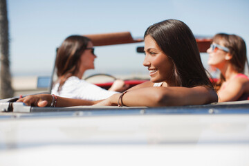 Wall Mural - Smiling woman sitting in convertible