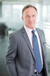© Chris Ryan/KOTO - Businessman standing in office hallway
