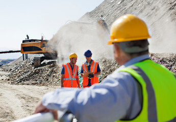 Wall Mural - Businessman watching workers in quarry