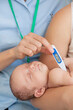 © Tom Merton/KOTO - Nurse taking baby's temperature