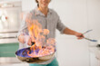 © Tom Merton/KOTO - Man cooking with fire in kitchen