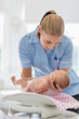 © Tom Merton/KOTO - Nurse weighing newborn baby