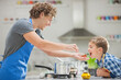 © Tom Merton/KOTO - Father and son cooking in kitchen
