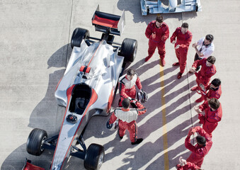 Team surrounding racer on track