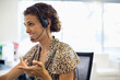 © Paul Bradbury/KOTO - Businesswoman talking on headset at desk