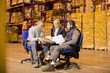 © Paul Bradbury/KOTO - Business people talking in warehouse