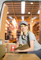 Wall Mural - Delivery girl checking boxes in van