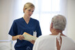 © Sam Edwards/KOTO - Nurse and older patient talking in hospital room