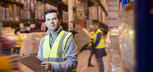 Worker using clipboard in warehouse