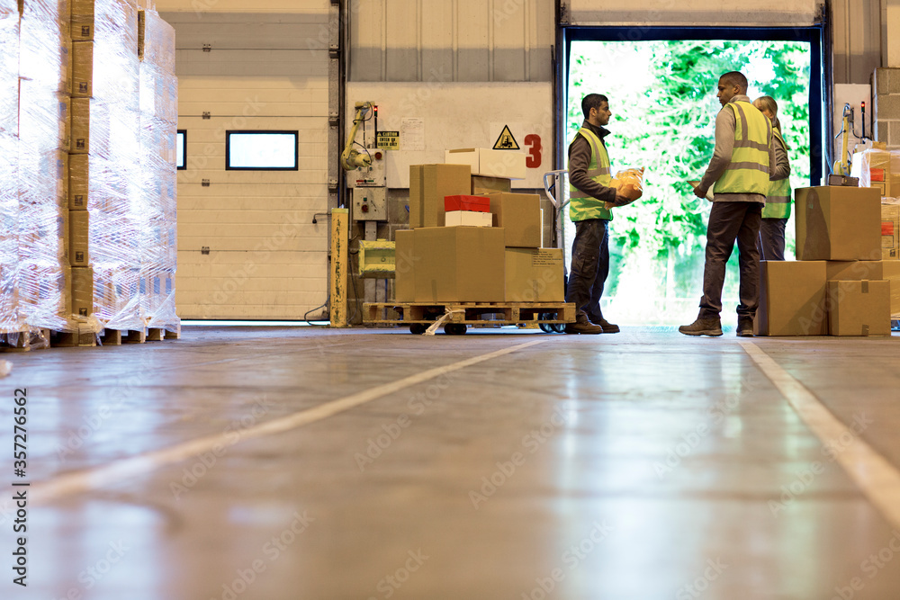 Workers talking in warehouse Stock Photo | Adobe Stock