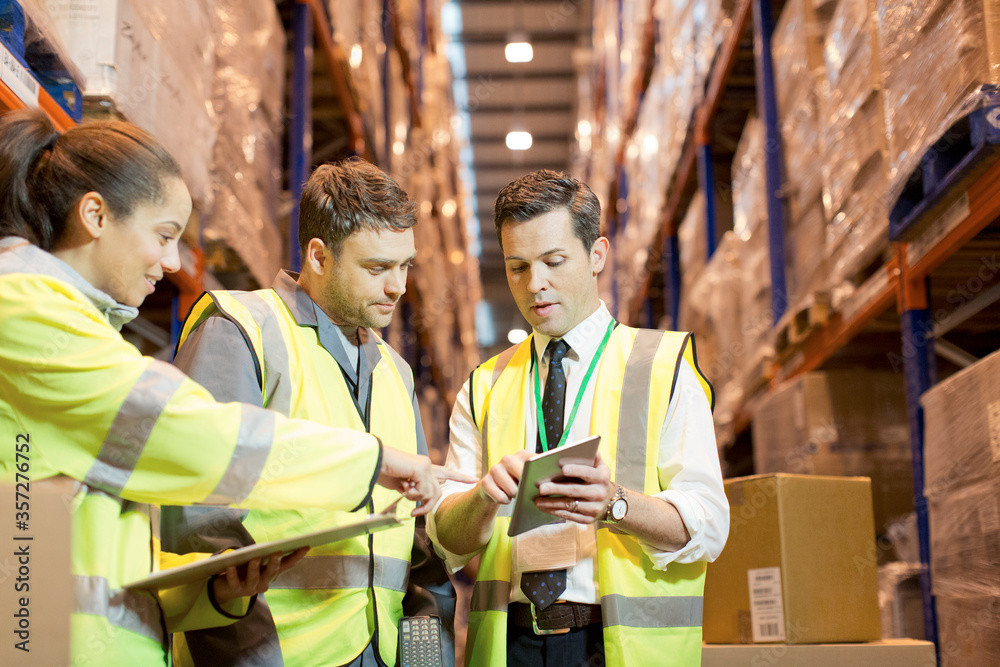 Businessman and workers talking in warehouse Stock Photo | Adobe Stock