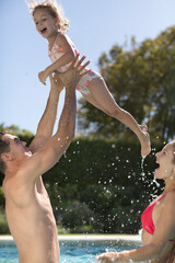 Wall Mural - Family playing in swimming pool