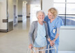 © Paul Bradbury/KOTO - Nurse helping senior patient with walker in hospital corridor