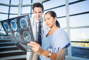 Wall Mural - Doctor and nurse viewing head x-rays on hospital staircase