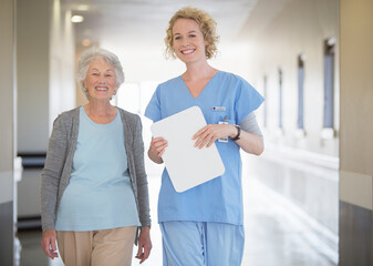 Wall Mural - Portrait of smiling nurse and senior patient in hospital corridor