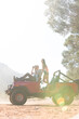 © Martin Barraud/KOTO - Couple relaxing in sport utility vehicle on dirt road