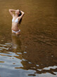 © Sam Edwards/KOTO - Woman standing with hands in hair in river