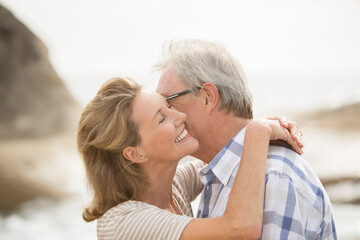 Older couple kissing on beach