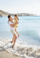 Poster - Mother and daughter playing in waves on beach