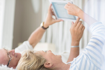 Wall Mural - Older couple using digital tablet on bed